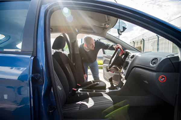 Person reaching into an unlocked car