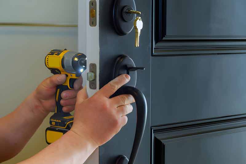Locksmith fitting hardware to a residential door